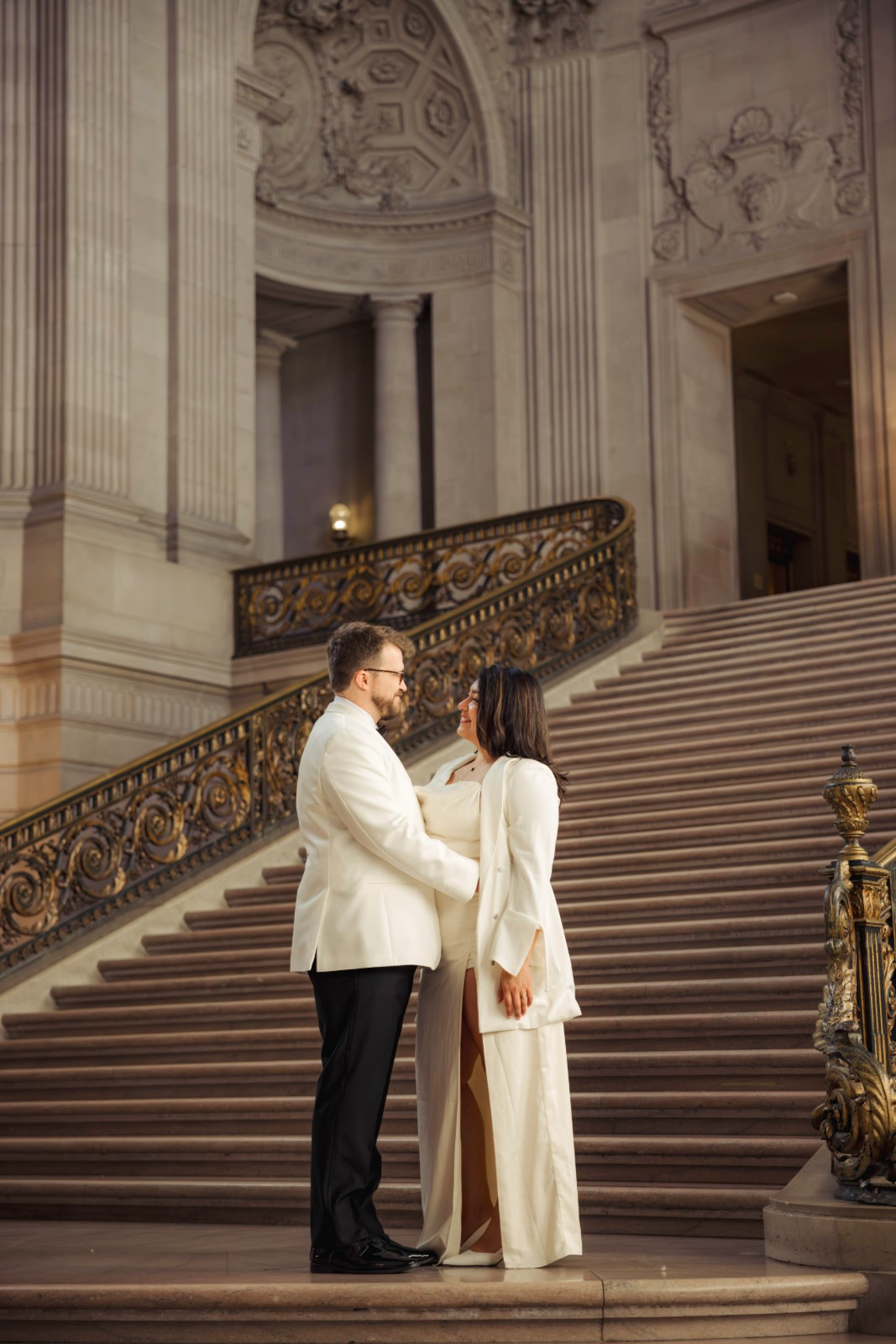 Couple on the grand staircase of San Francisco City Hall during their wedding by SlowMo Studio