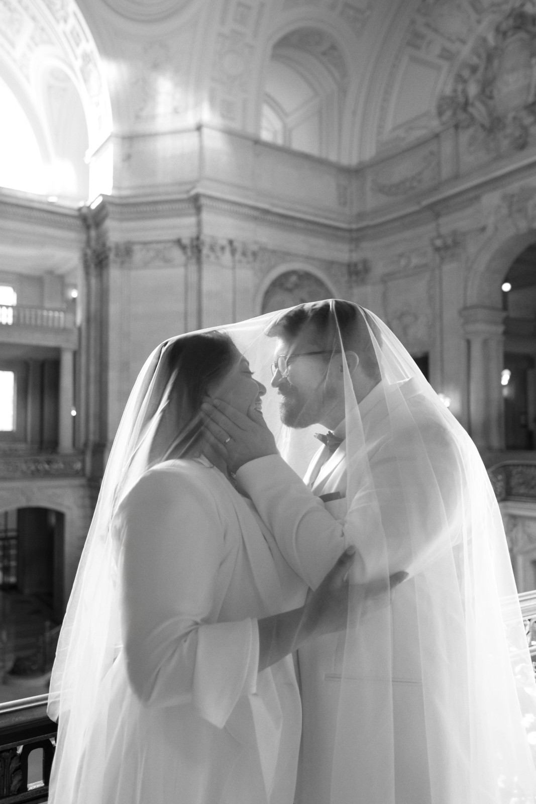 Couple embracing in the rotunda of San Francisco City Hall by SlowMo Studio